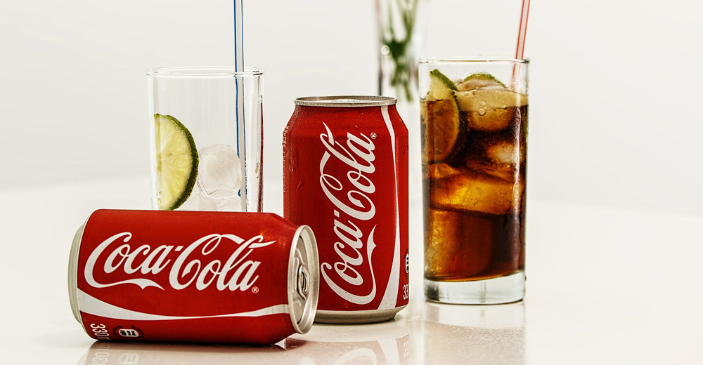 Coca-Cola cans with glass cups.