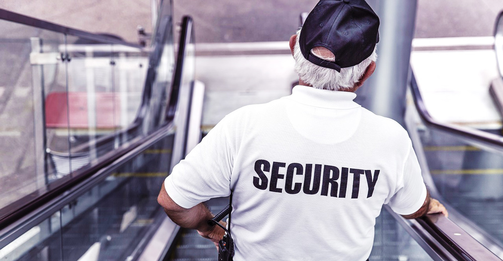 Security guy going down an escalator.