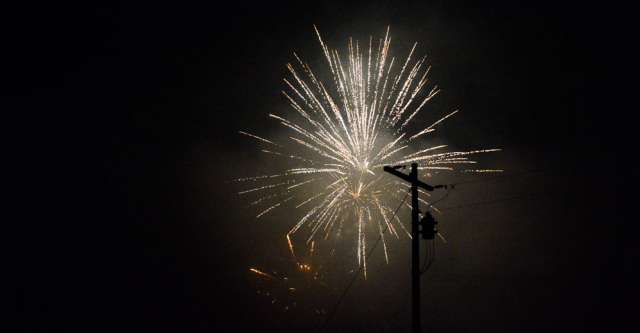 Fireworks behind the electric pole.