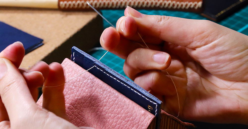 Person sewing leather together.