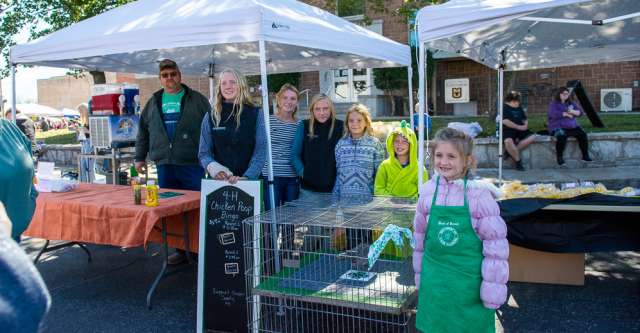 A group of kids in 4-H pose next to the chicken poop bingo at the Walnut Festival on October 7, 2023.