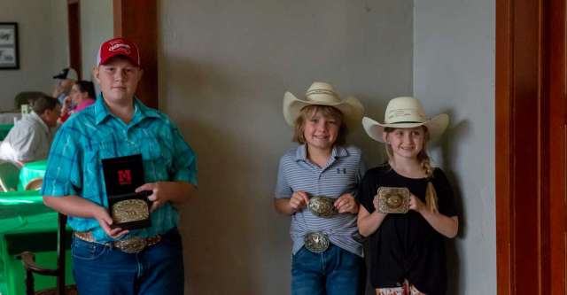 (Left to right) Wyatt Medlin, Landry Gleghorn, and Myla Woods holding up their belt buckles they got at the Texas County Fair.