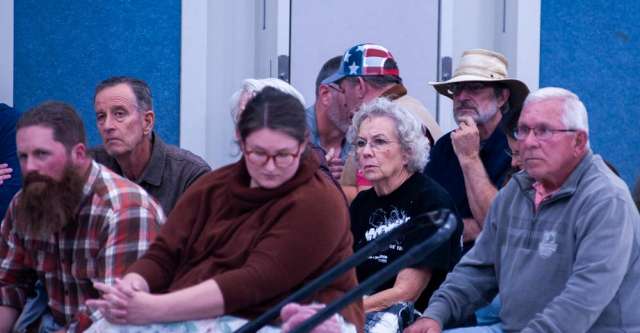 The crowd listens to each of the speakers as well as the board.