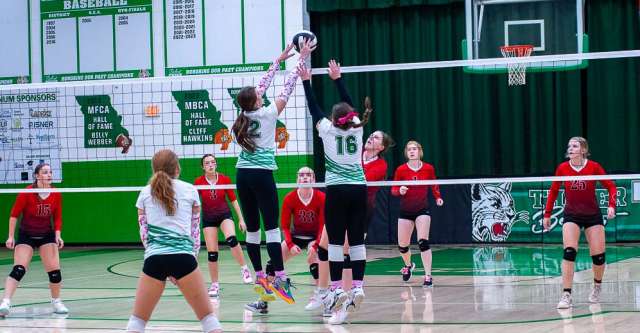 THAYER, MO – OCTOBER 10: Two Thayer Bobcat players jump up to block the ball during the high school volleyball game between the Couch Indians and the Thayer Bobcats on October 10, 2024, at the Thayer High School Gym in Thayer, Missouri. (Photo by Amanda Thomas/AltonMo.com)