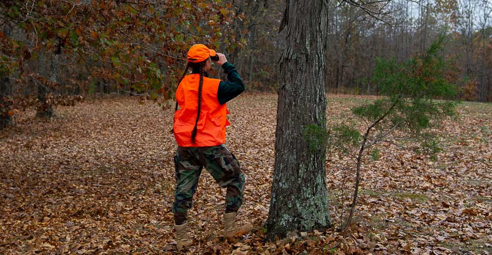 A hunter looking out across a clearing.